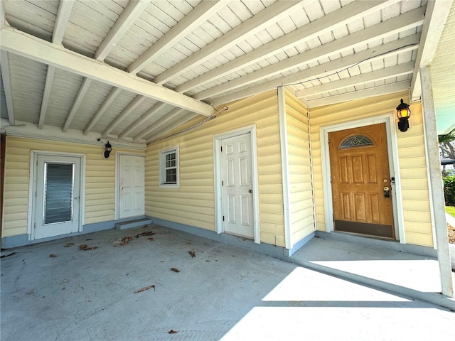 view of exterior entry with a patio area