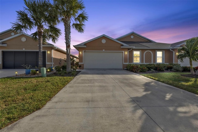 single story home with a garage and a lawn