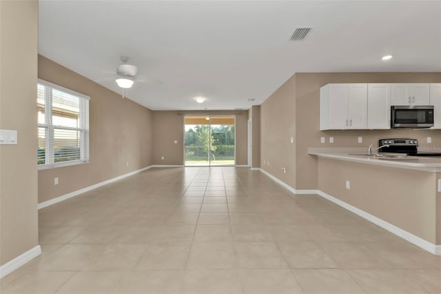 kitchen featuring white cabinetry, black stove, light tile patterned floors, and ceiling fan