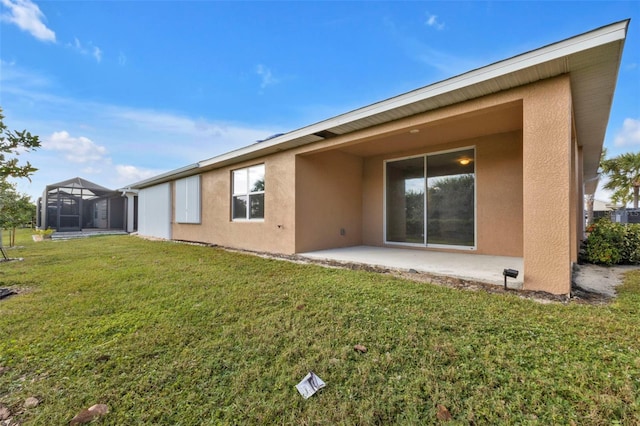 back of house with a patio area, a lawn, and a lanai