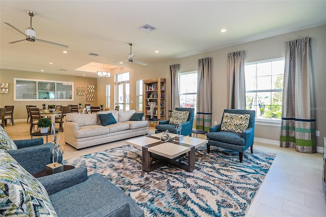 living room featuring light tile patterned flooring and ceiling fan with notable chandelier