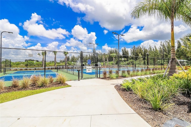 view of home's community with tennis court