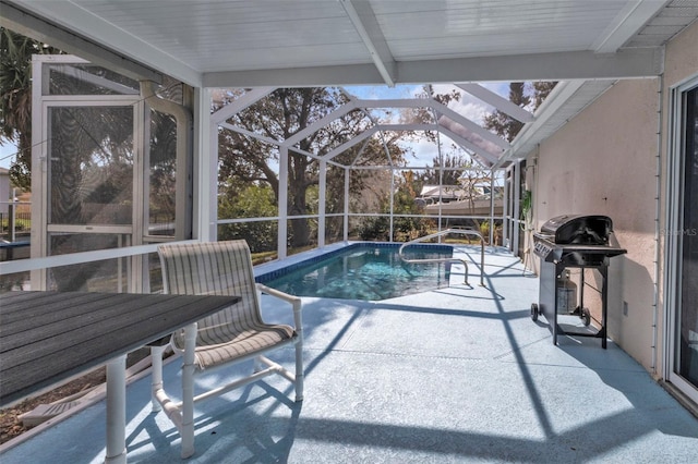 view of swimming pool featuring a grill, a patio area, and a lanai