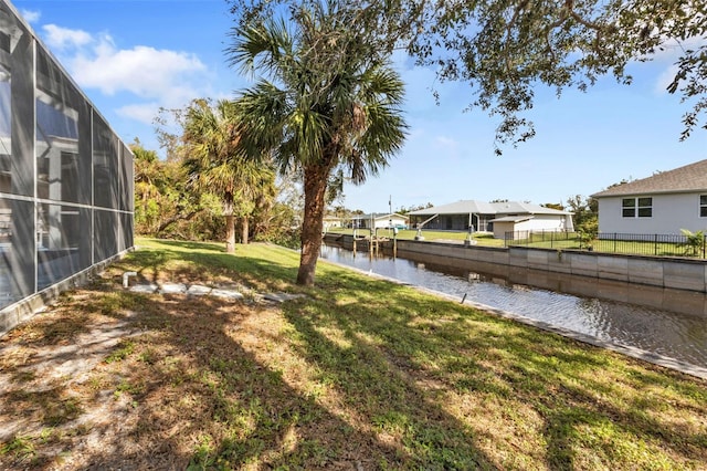 view of yard featuring a water view and glass enclosure