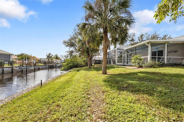 view of yard with a water view and a lanai