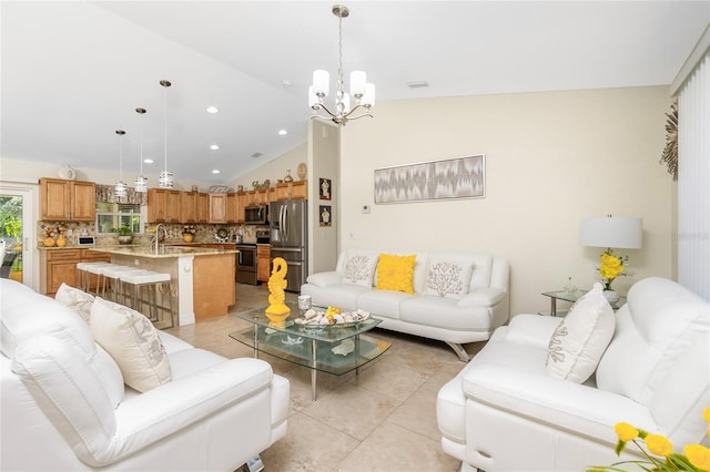 living room featuring light tile patterned floors, vaulted ceiling, a notable chandelier, and sink