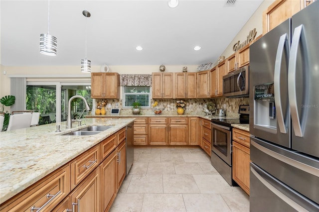 kitchen with pendant lighting, sink, decorative backsplash, light stone countertops, and stainless steel appliances