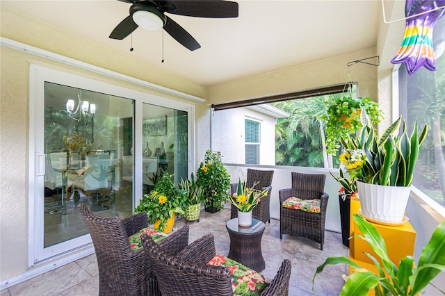 sunroom with ceiling fan with notable chandelier