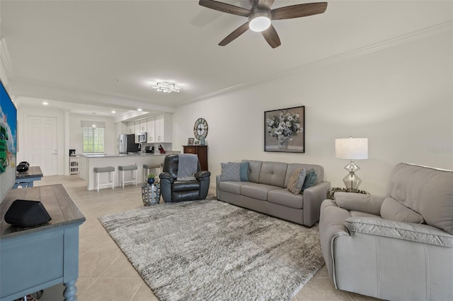 living room featuring ceiling fan, light tile patterned floors, and ornamental molding