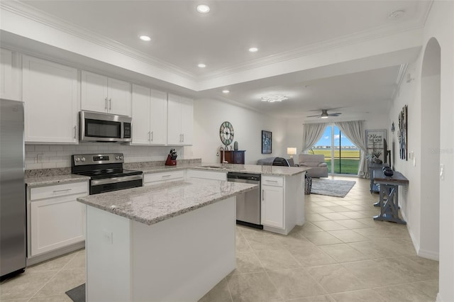 kitchen with kitchen peninsula, ceiling fan, white cabinets, and stainless steel appliances