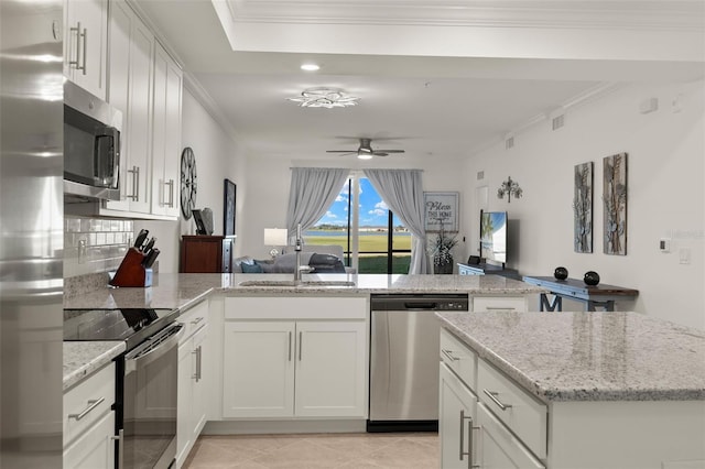 kitchen with white cabinets, ceiling fan, light stone counters, and stainless steel appliances