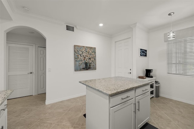 kitchen with white cabinets, light stone countertops, a kitchen island, and pendant lighting