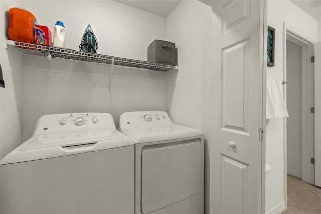 laundry room with independent washer and dryer and light tile patterned floors