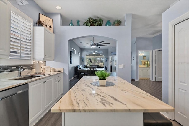 kitchen featuring white cabinets, dark wood-type flooring, stainless steel dishwasher, and a kitchen island