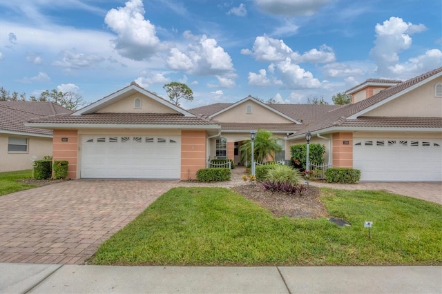 single story home with a garage and a front lawn