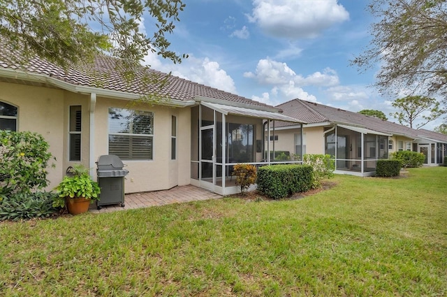 back of house featuring a sunroom and a yard