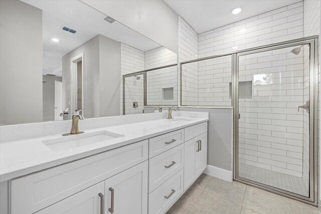 bathroom featuring tile patterned flooring, vanity, and a shower with shower door