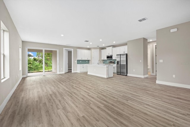 unfurnished living room with light wood-type flooring and sink