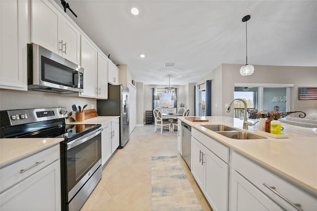 14271 Heritage Landing Blvd Unit 1526, Punta Gorda, FL 33955 - kitchen with light countertops, white cabinetry, a sink, appliances with stainless steel finishes, and decorative light fixtures