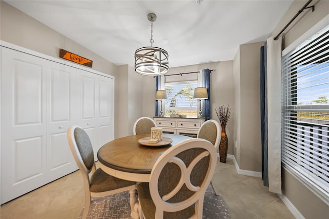 dining space with a healthy amount of sunlight, light tile patterned flooring, and an inviting chandelier