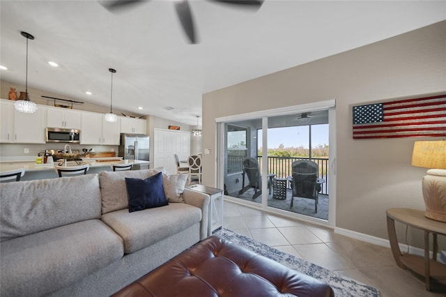 living room featuring ceiling fan, vaulted ceiling, and light tile patterned floors