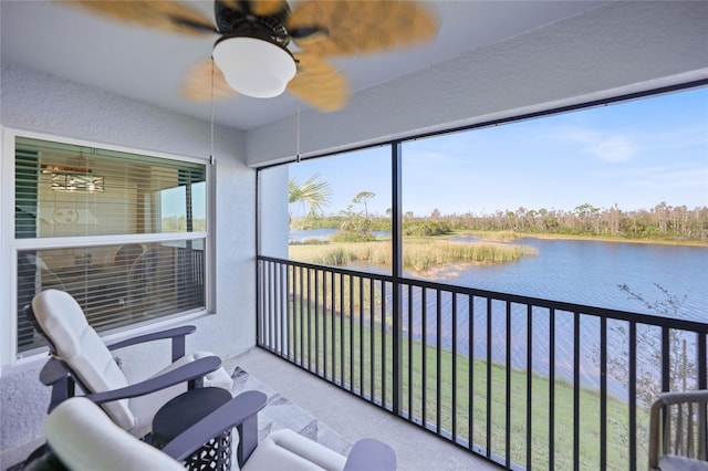 sunroom / solarium with a water view and ceiling fan