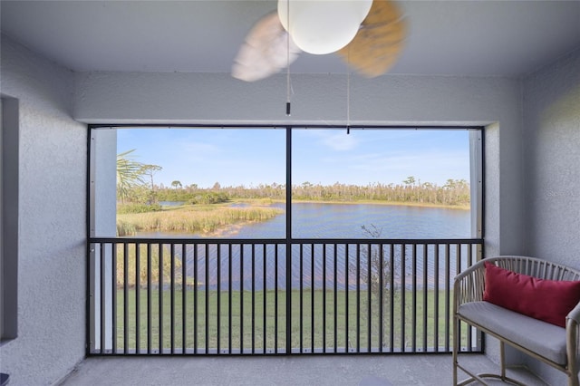 sunroom featuring a water view