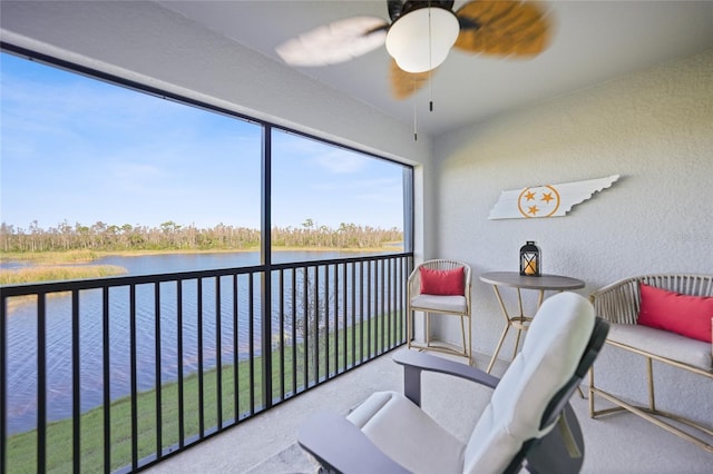 sunroom with a water view and ceiling fan