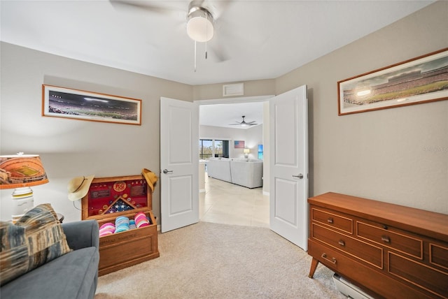 living area featuring light carpet and ceiling fan