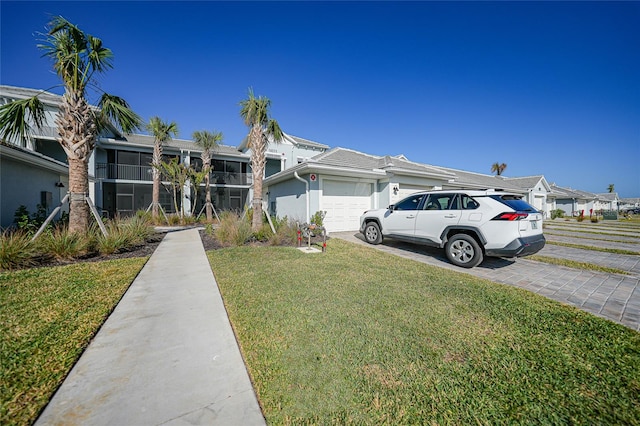 ranch-style house featuring a front yard and a garage