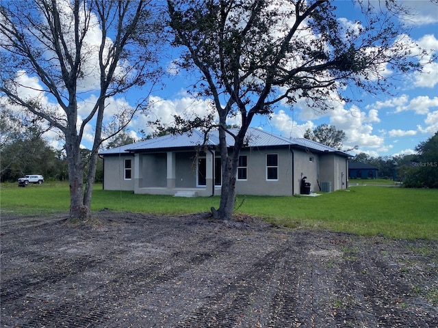 view of front of house featuring central AC unit and a front lawn