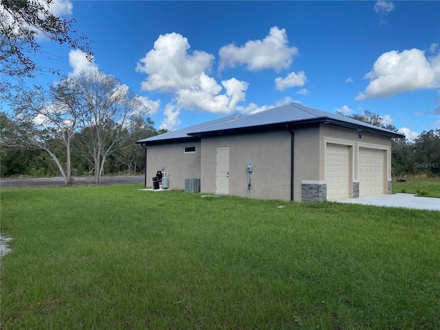 view of side of home with central AC unit and a yard