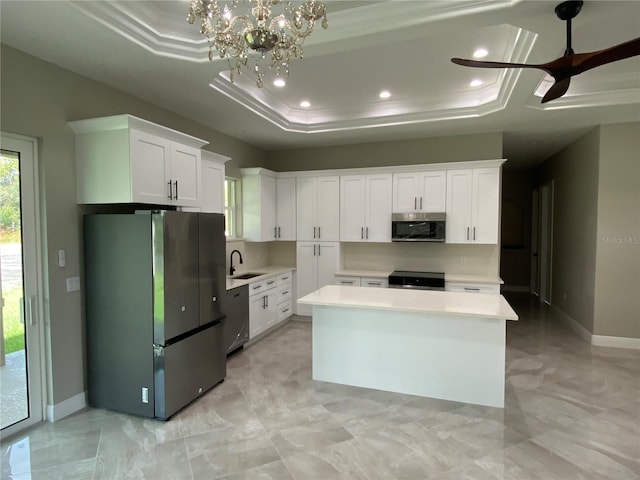 kitchen featuring white cabinets, appliances with stainless steel finishes, and a tray ceiling