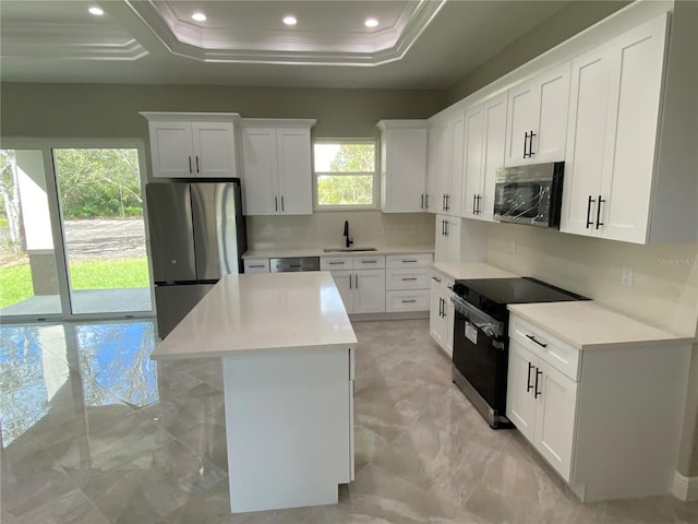 kitchen featuring stainless steel appliances, white cabinetry, and a kitchen island