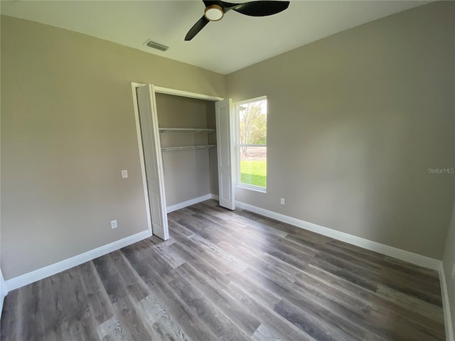 unfurnished bedroom featuring a closet, ceiling fan, and dark wood-type flooring