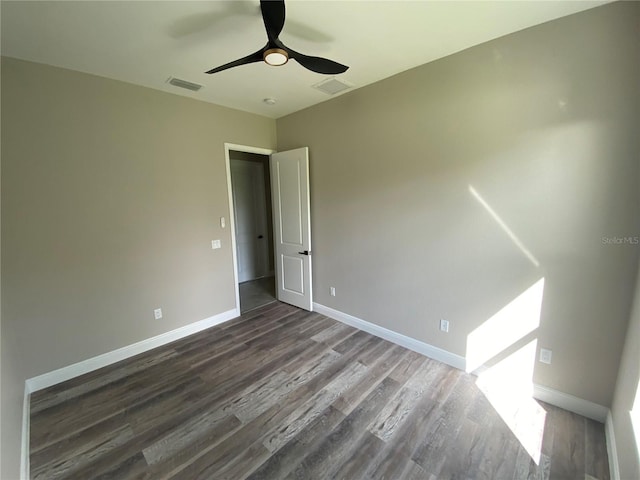 spare room with ceiling fan and dark wood-type flooring