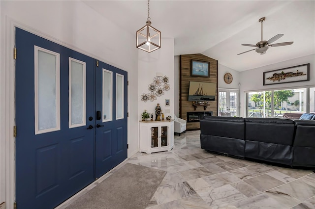 entrance foyer featuring french doors, a fireplace, wooden walls, lofted ceiling, and ceiling fan