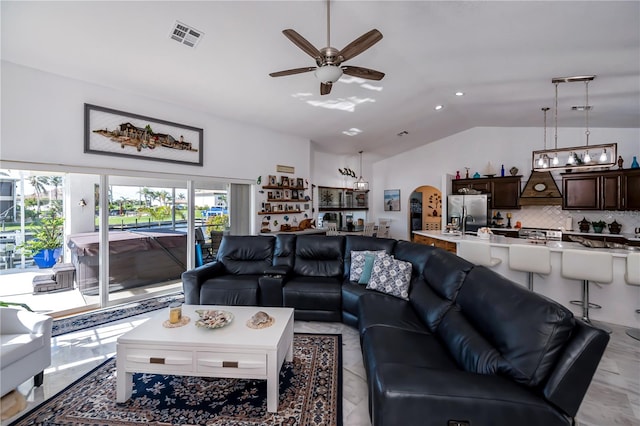 living room featuring ceiling fan and vaulted ceiling