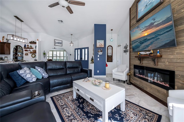 living room with high vaulted ceiling, wooden walls, and ceiling fan