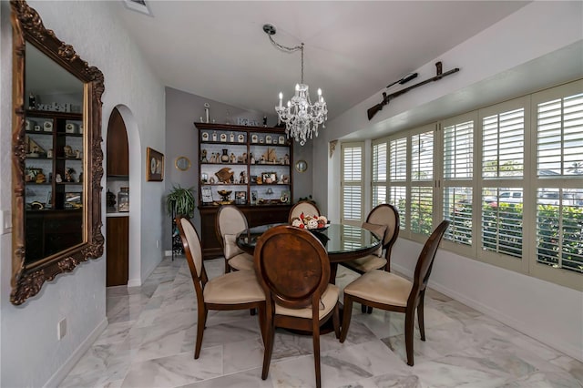 dining space featuring lofted ceiling and an inviting chandelier