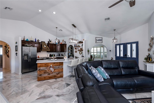 living room featuring lofted ceiling and ceiling fan with notable chandelier