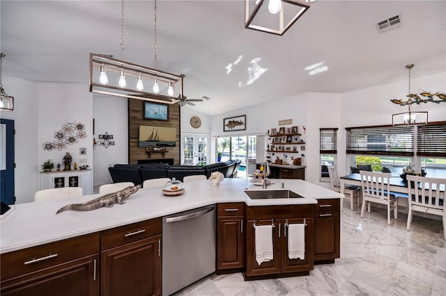 kitchen with sink, stainless steel dishwasher, pendant lighting, and vaulted ceiling