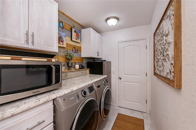 clothes washing area featuring washer and dryer and a textured ceiling