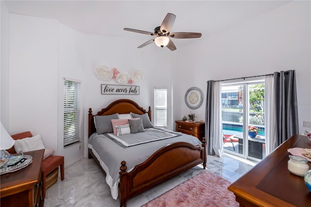 bedroom featuring access to exterior, ceiling fan, and a high ceiling