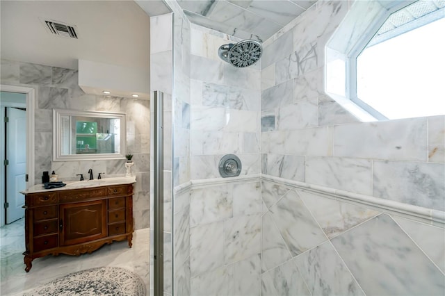 bathroom with vanity, tile walls, and a tile shower