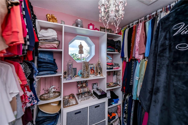 walk in closet featuring a notable chandelier