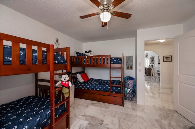 bedroom featuring ceiling fan and a textured ceiling