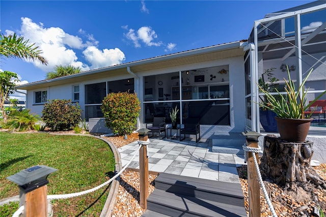 view of front of house with a front yard, glass enclosure, and a patio area