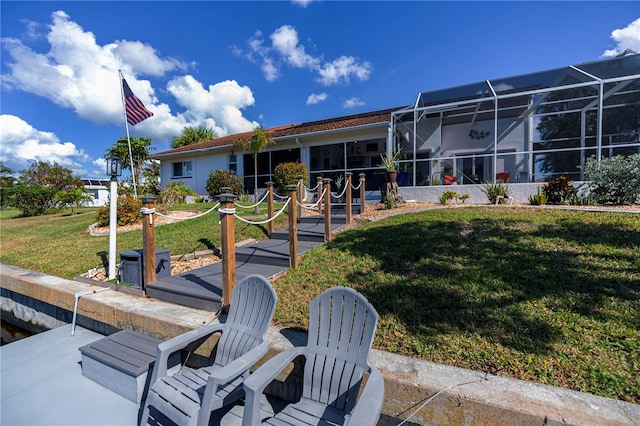 back of house featuring a lawn, a lanai, and a patio area