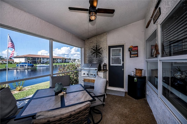 sunroom featuring a water view, lofted ceiling, and ceiling fan